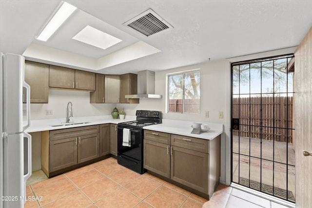 kitchen featuring sink, white refrigerator, light tile patterned floors, black range with electric stovetop, and wall chimney range hood