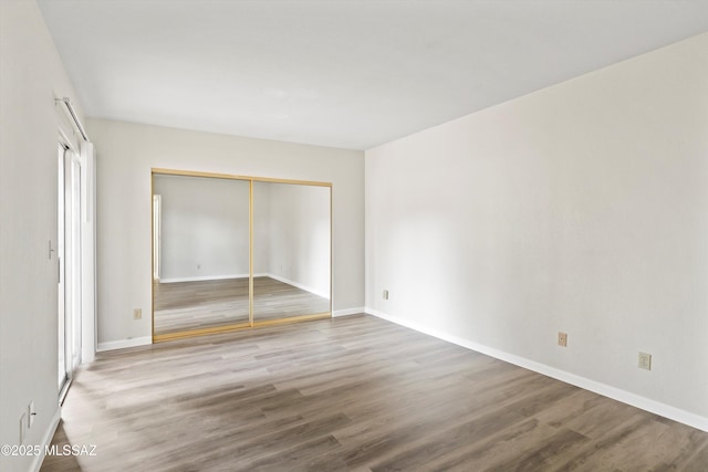 unfurnished bedroom with hardwood / wood-style flooring and a closet