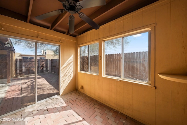 unfurnished sunroom with beamed ceiling and ceiling fan