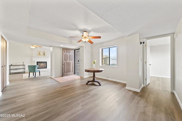 interior space with ceiling fan, a textured ceiling, and light wood-type flooring