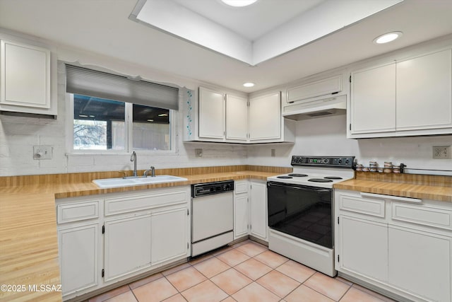 kitchen with under cabinet range hood, light tile patterned floors, white appliances, white cabinetry, and a sink