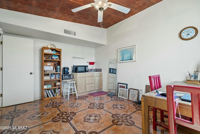 office area featuring tile patterned floors, visible vents, an ornate ceiling, and a ceiling fan