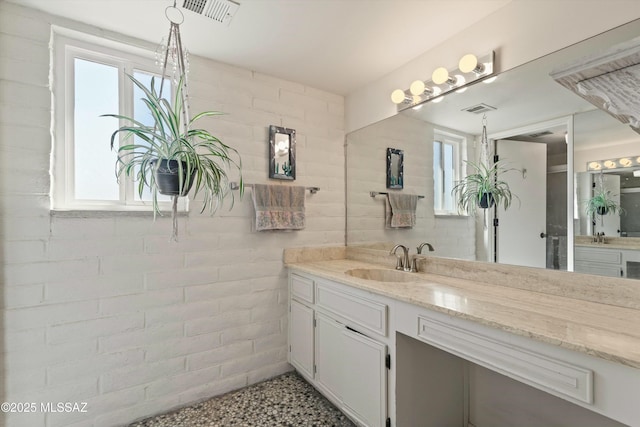 bathroom featuring visible vents, a healthy amount of sunlight, and vanity