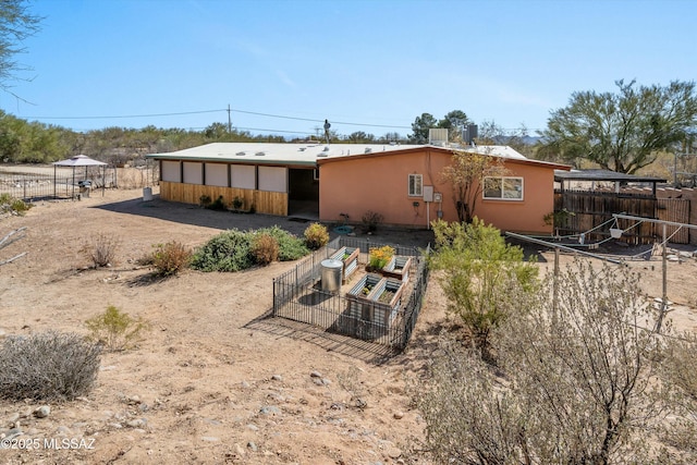 back of house with stucco siding and fence