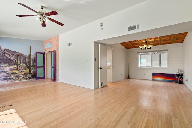 unfurnished living room featuring visible vents, ceiling fan with notable chandelier, and wood finished floors