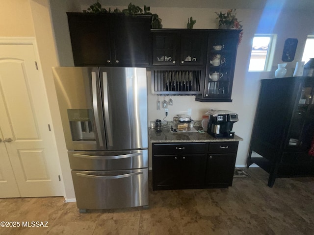 kitchen featuring stainless steel fridge and light stone countertops