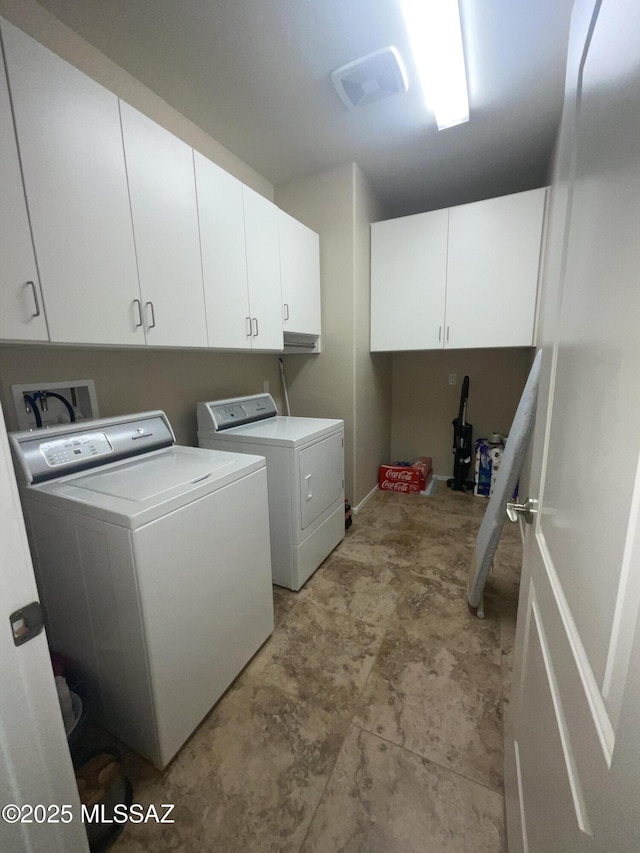 laundry room featuring cabinets and washer and clothes dryer