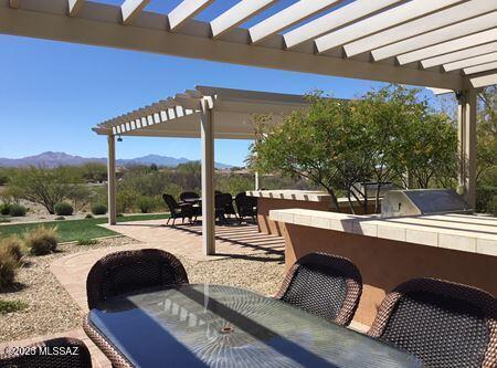 view of patio with a mountain view, a pergola, and an outdoor bar