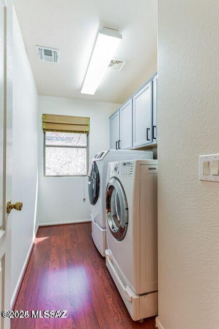 laundry room with wood finished floors, visible vents, cabinet space, and separate washer and dryer