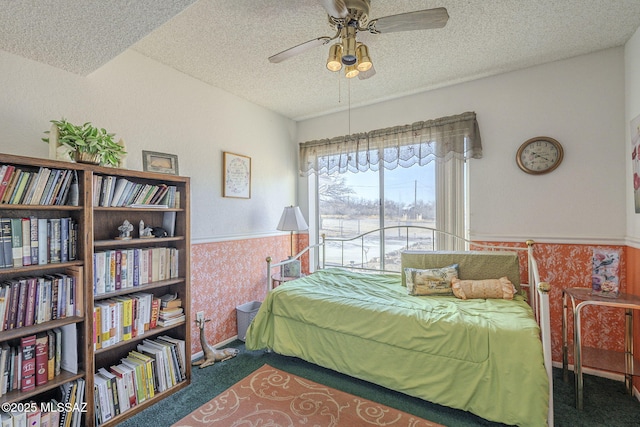 bedroom featuring dark colored carpet, ceiling fan, and a textured ceiling