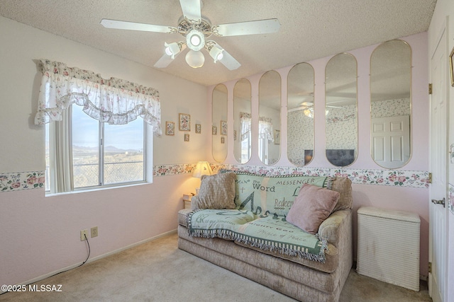 living room with ceiling fan, a textured ceiling, and carpet flooring