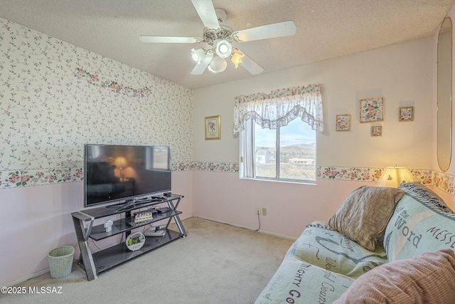 living room with ceiling fan, light carpet, and a textured ceiling