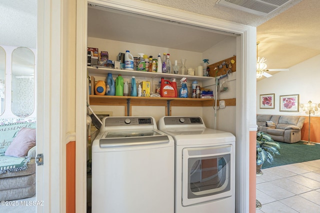 laundry room featuring light tile patterned flooring, ceiling fan, washer and clothes dryer, and a textured ceiling