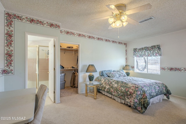 bedroom with a walk in closet, carpet flooring, a closet, and a textured ceiling