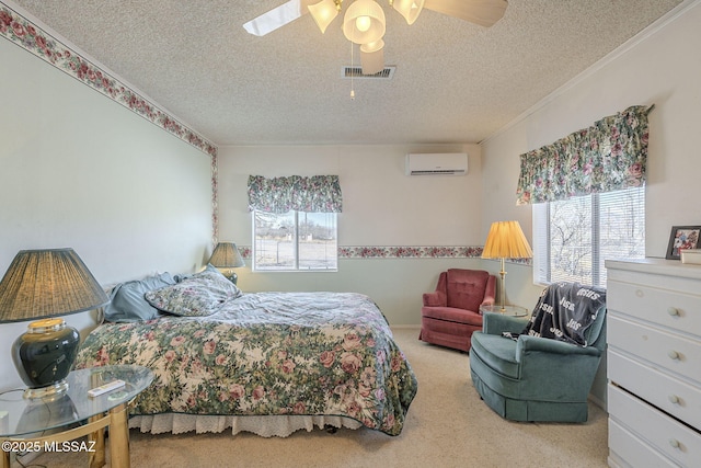 bedroom featuring a wall mounted air conditioner, ornamental molding, light colored carpet, ceiling fan, and a textured ceiling