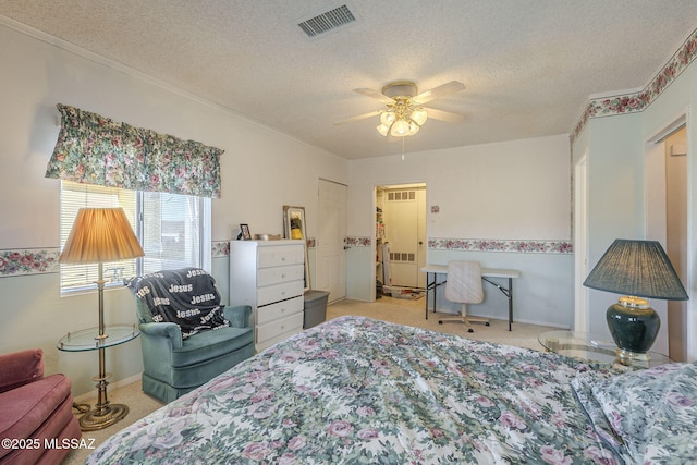 bedroom featuring ceiling fan, light colored carpet, and a textured ceiling