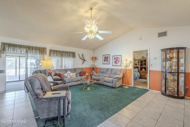 living room with lofted ceiling, tile patterned flooring, a textured ceiling, and ceiling fan