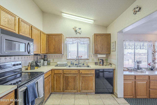 kitchen featuring sink, vaulted ceiling, a textured ceiling, light tile patterned floors, and black appliances