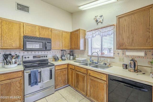 kitchen with light tile patterned flooring, backsplash, sink, and black appliances
