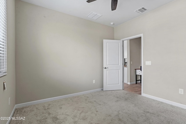 empty room with a ceiling fan, baseboards, visible vents, and carpet flooring