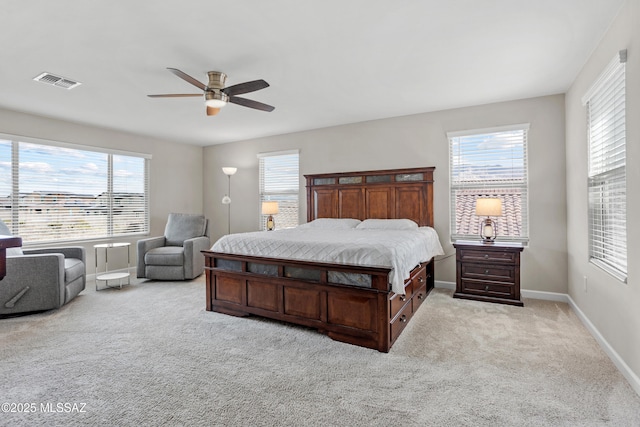 bedroom featuring light carpet, baseboards, multiple windows, and visible vents