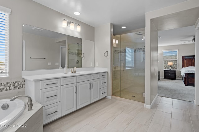 ensuite bathroom featuring a healthy amount of sunlight, a stall shower, connected bathroom, and vanity