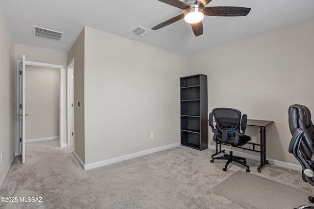 carpeted office with baseboards, visible vents, and a ceiling fan