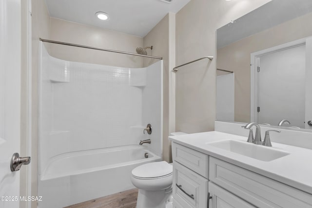 full bath with wood finished floors, tub / shower combination, vanity, and toilet