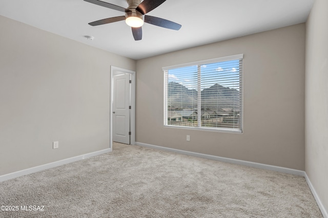 spare room featuring ceiling fan, carpet flooring, and baseboards