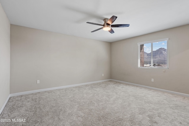 carpeted empty room featuring ceiling fan and baseboards