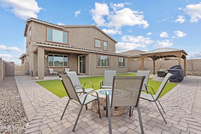 rear view of house with a patio, stucco siding, a gazebo, a gate, and a fenced backyard