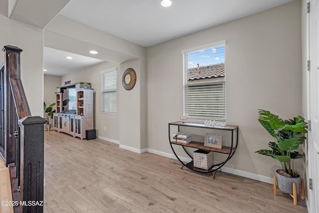 interior space with baseboards, wood finished floors, and a healthy amount of sunlight