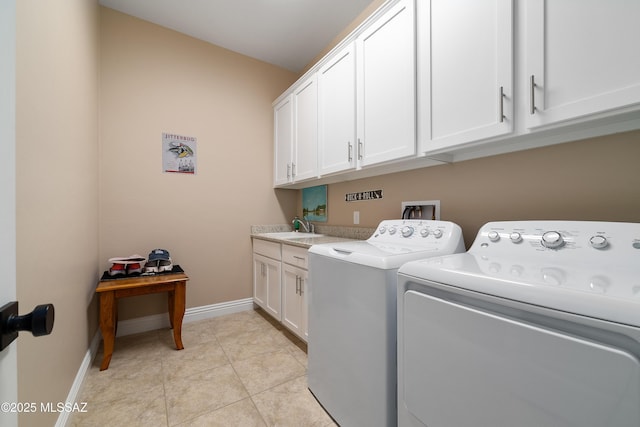 clothes washing area featuring a sink, cabinet space, baseboards, and washer and dryer