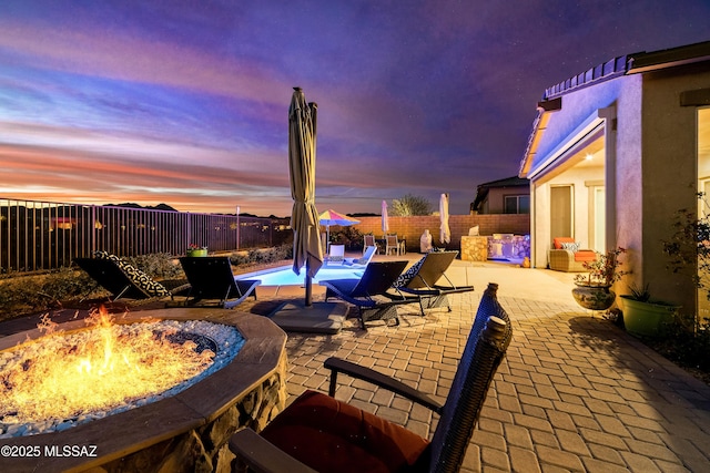 view of patio featuring a fire pit, a fenced backyard, and a fenced in pool