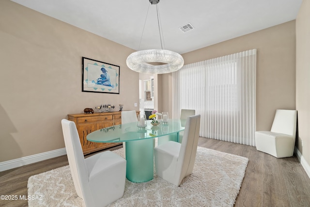 dining area featuring wood finished floors, visible vents, and baseboards