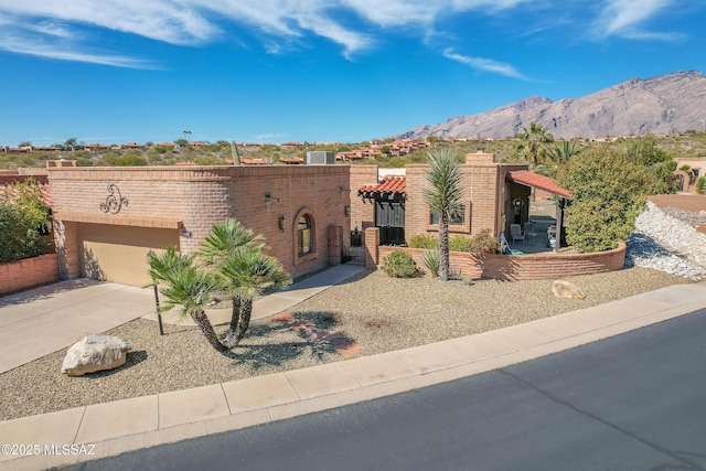 view of front of home featuring driveway, an attached garage, and a mountain view