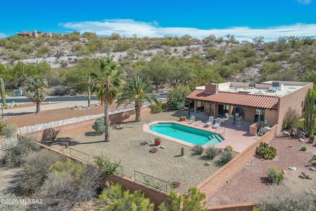 outdoor pool with a fenced backyard and a patio