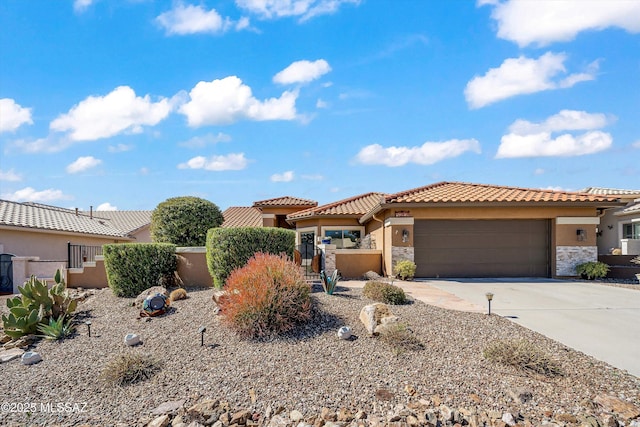 view of front of property with a garage, driveway, stone siding, a tile roof, and stucco siding