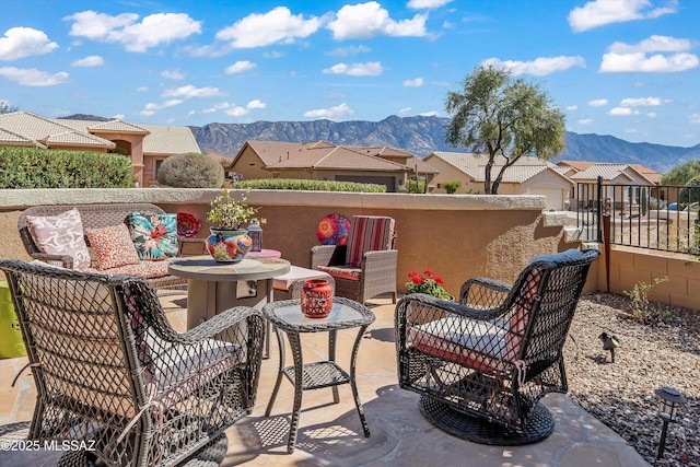 view of patio / terrace with a residential view, a mountain view, an outdoor living space, and fence