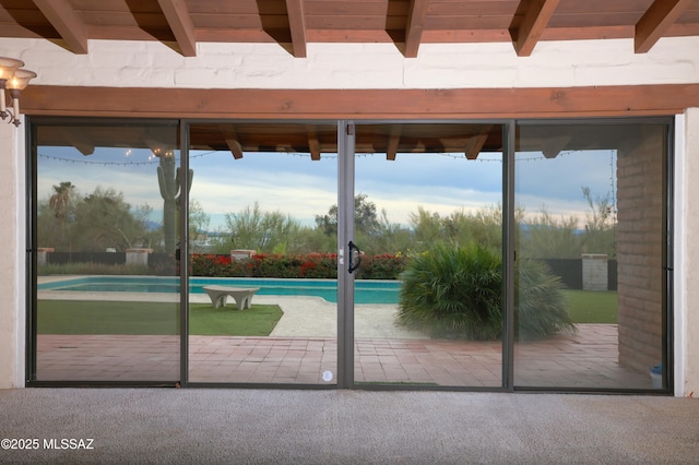 entryway featuring carpet floors, plenty of natural light, and beam ceiling