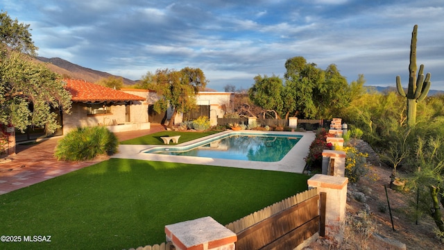 view of swimming pool featuring a fenced in pool, a yard, a patio, a mountain view, and a fenced backyard