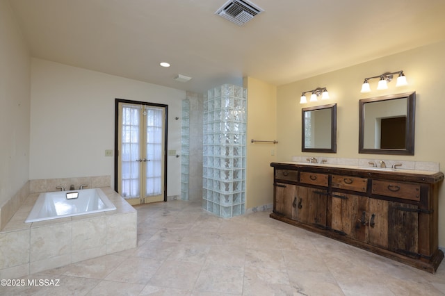 bathroom with double vanity, visible vents, tile patterned floors, french doors, and a bath