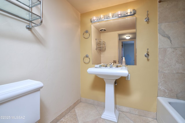 full bath featuring toilet, a bathing tub, visible vents, baseboards, and tile patterned floors