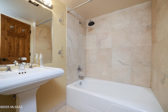 bathroom featuring  shower combination, visible vents, a sink, and tile patterned floors