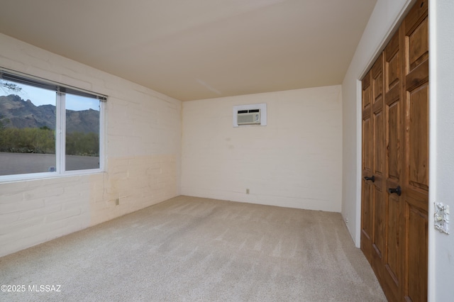 spare room featuring a wall unit AC, light carpet, and a mountain view