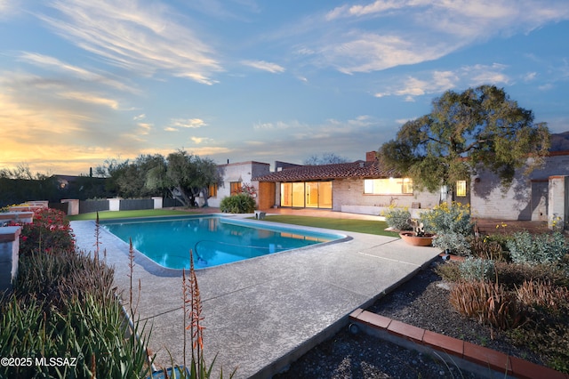 view of swimming pool featuring a patio area, fence, and a fenced in pool