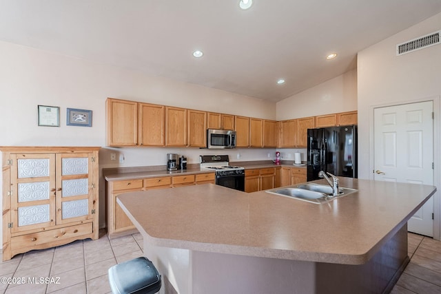 kitchen with black fridge with ice dispenser, visible vents, a large island, stainless steel microwave, and gas range