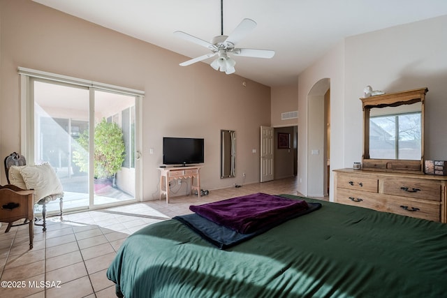 bedroom with light tile patterned floors, visible vents, arched walkways, access to exterior, and vaulted ceiling