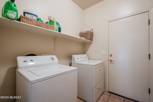 washroom with laundry area, washing machine and dryer, and light tile patterned floors