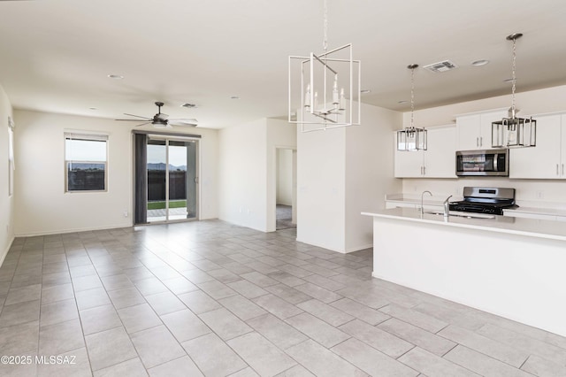 kitchen featuring decorative light fixtures, ceiling fan, appliances with stainless steel finishes, white cabinets, and light tile patterned flooring